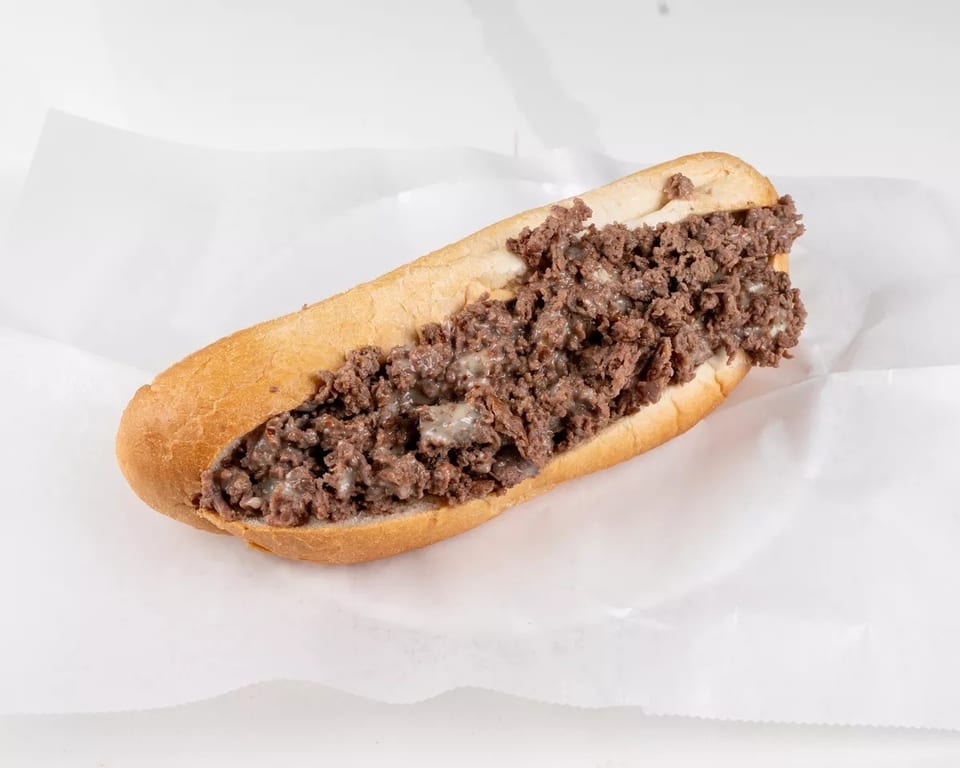 A classic cheesesteak sandwich with chopped meat and melted cheese on a long roll.